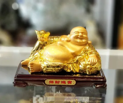 Phật di lạc vàng bóng tay cầm nén vàng nằm trên túi tài lộc vàng đế gỗ - Tài Nguyên Cuồn Cuộn FLN190